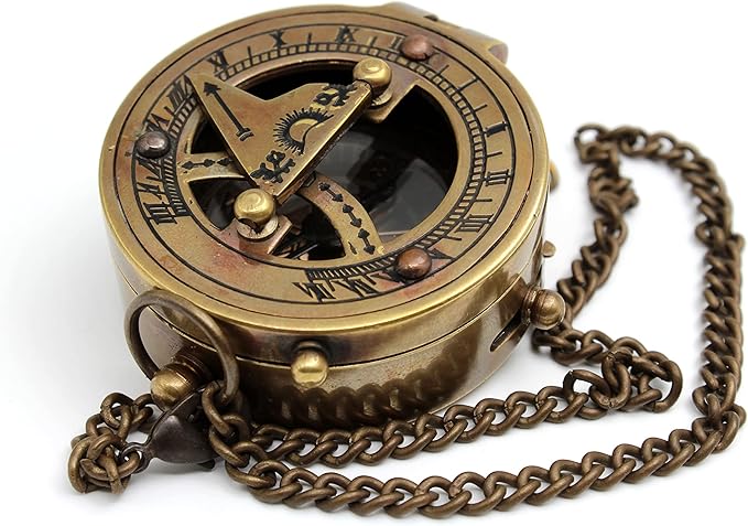 Vintage brass sundial compass used as decorative piece on a study desk.