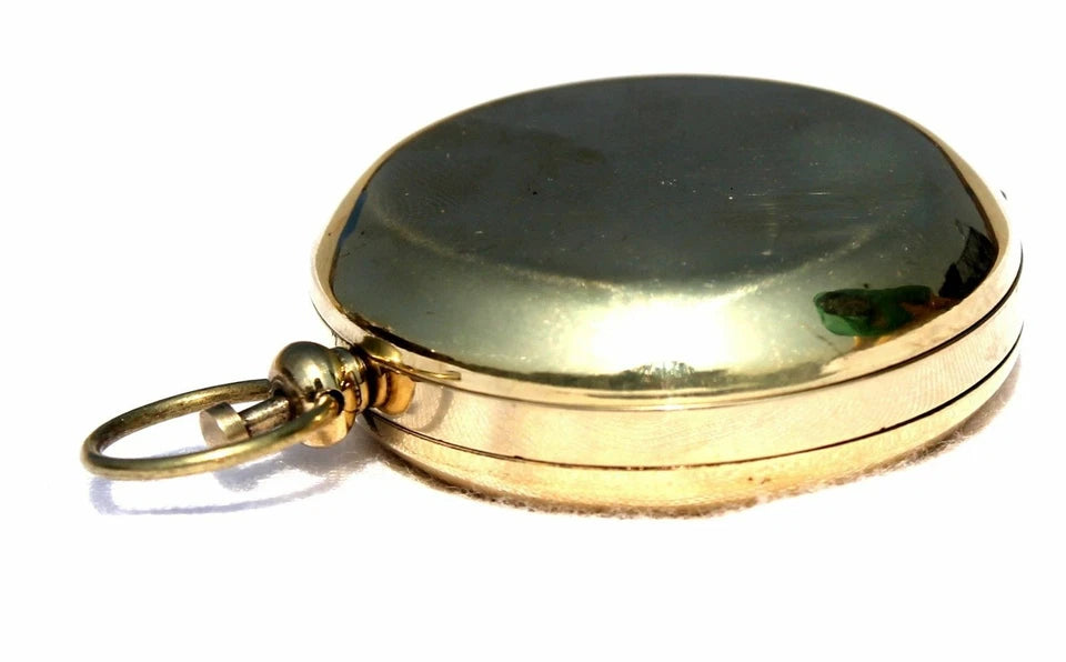 Close-up side view of Artisans Hub nautical brass push-button pocket compass