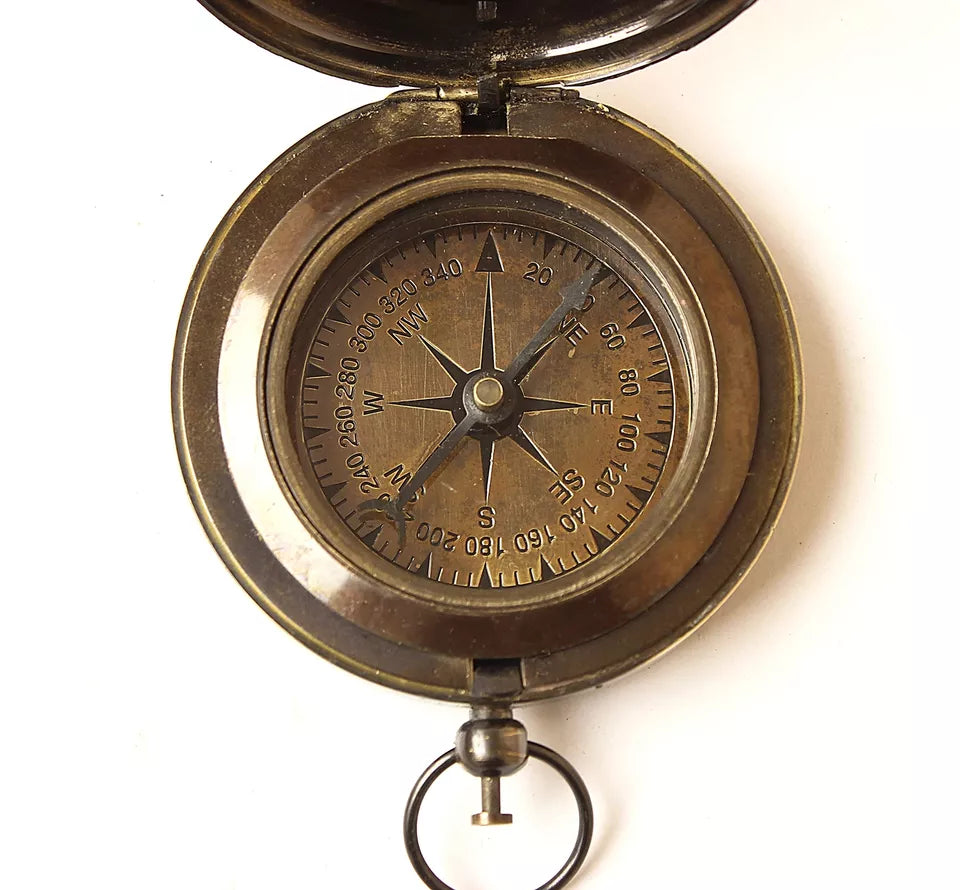 Top-down view of opened Artisans Hub brass compass displaying inner rose dial