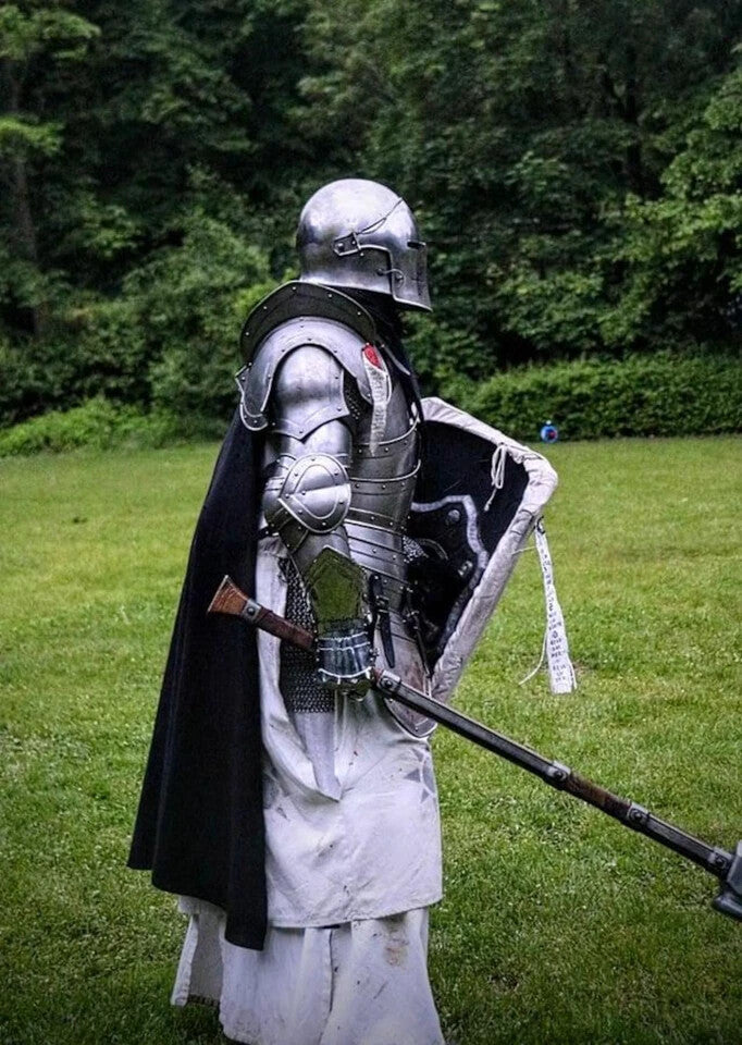 Side view of full-body Barbuta armor suit with polished steel finish, wearable medieval knight plate armor by Artisans Hub.