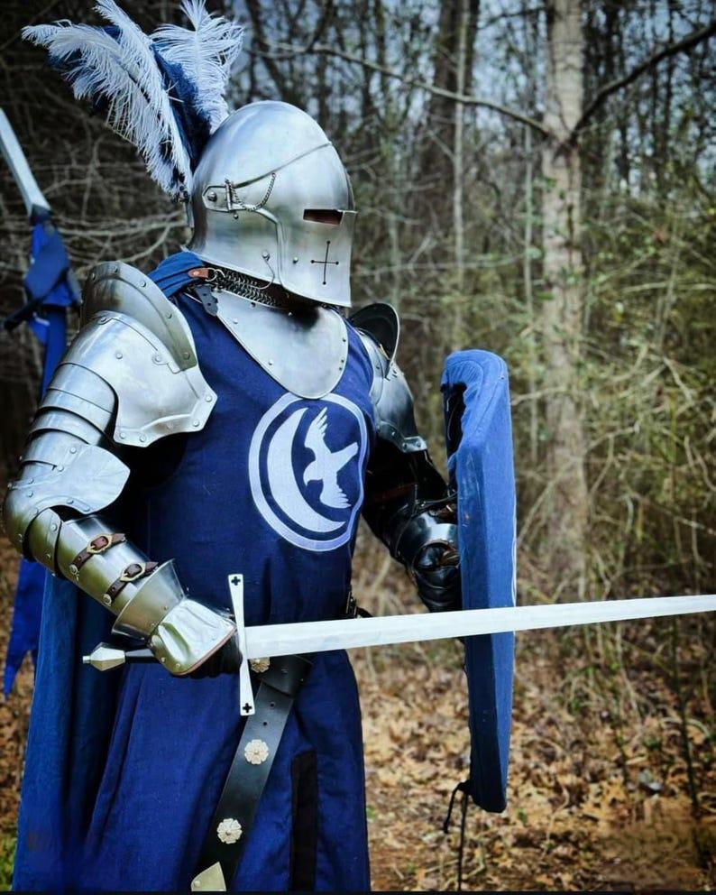 Close-up of the Barbuta-style helmet featuring a cross detail and visor, handcrafted in 18 gauge steel for an authentic medieval knight look.