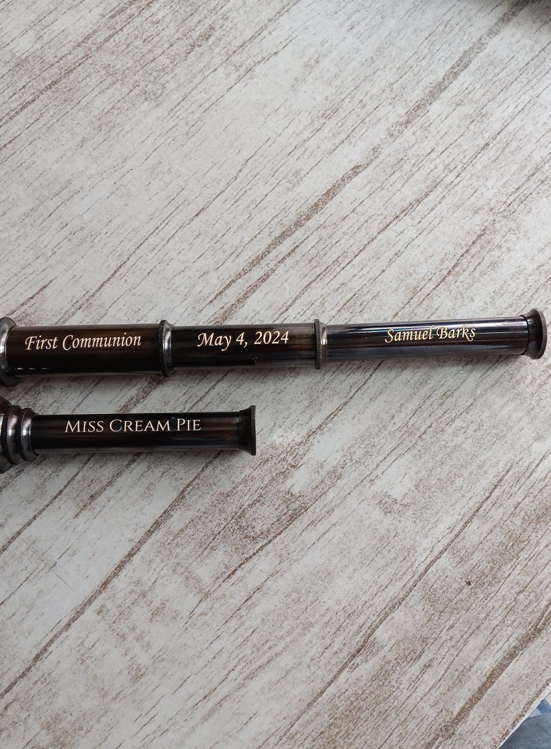 Engraving options shown on three sides of brass telescope