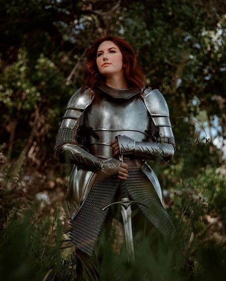 Close-up of the shoulder pauldrons and gorget on the women's knight armor suit, handcrafted from polished steel for LARP or cosplay.