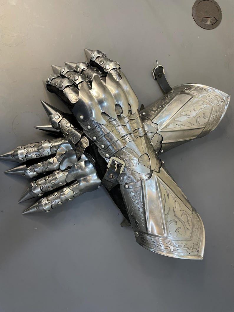 Close-up of Gothic knight hand armor showing etched steel and premium medieval design