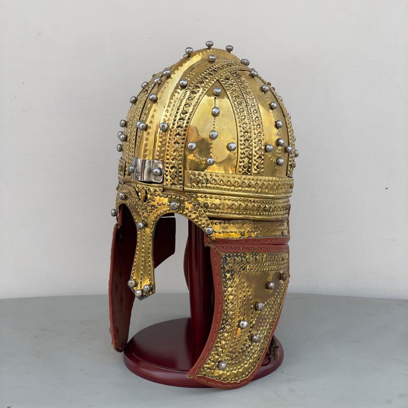 Close-up of handmade medieval Roman-style helmet featuring detailed nasal guard and polished brass finish.