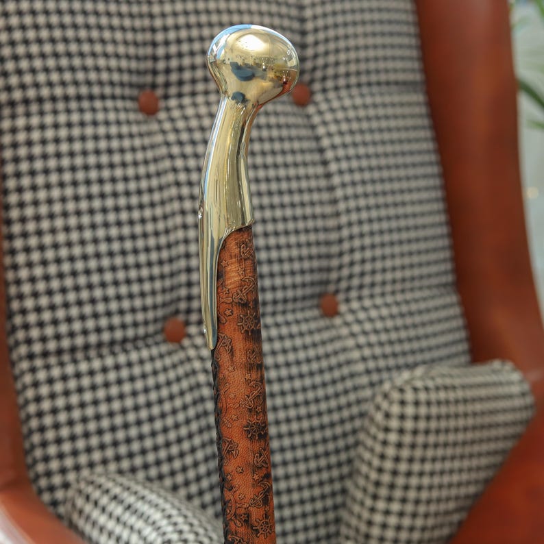 Polished brass handle walking cane with carved wooden shaft, stylish walking stick