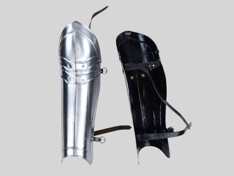 Close-up of LARP-ready medieval steel leg armor showing polished finish and rolled edges