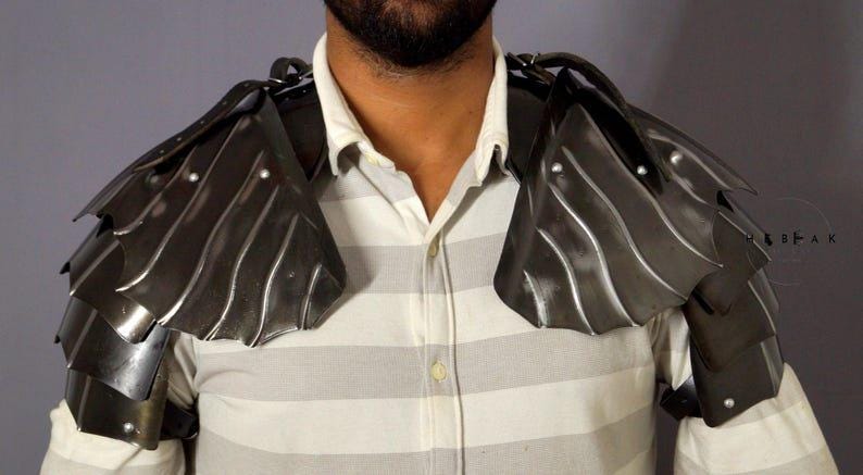 Full leg armor set with greaves and sabatons in blackened steel, adjustable for adult sizing, part of the Nazgûl costume ensemble.