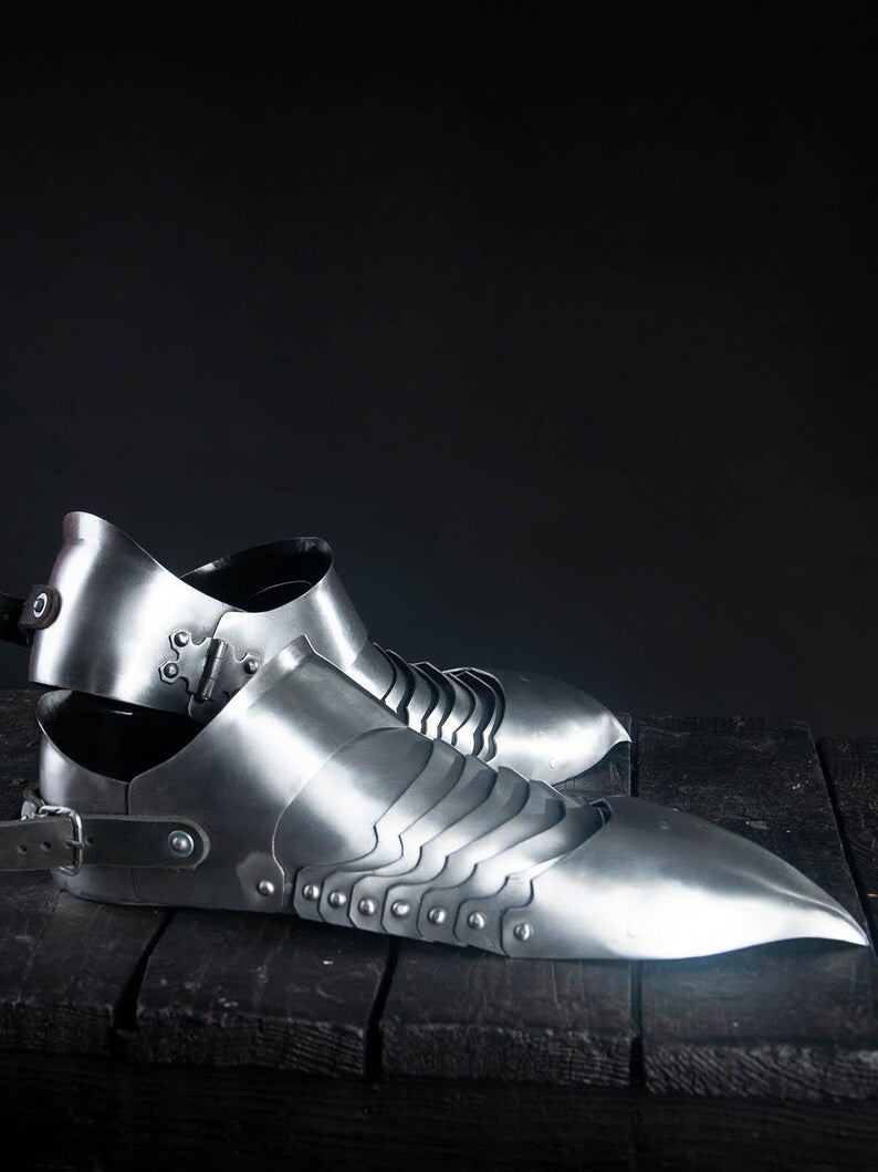 Medieval armor sabatons with sturdy brown leather straps and polished steel