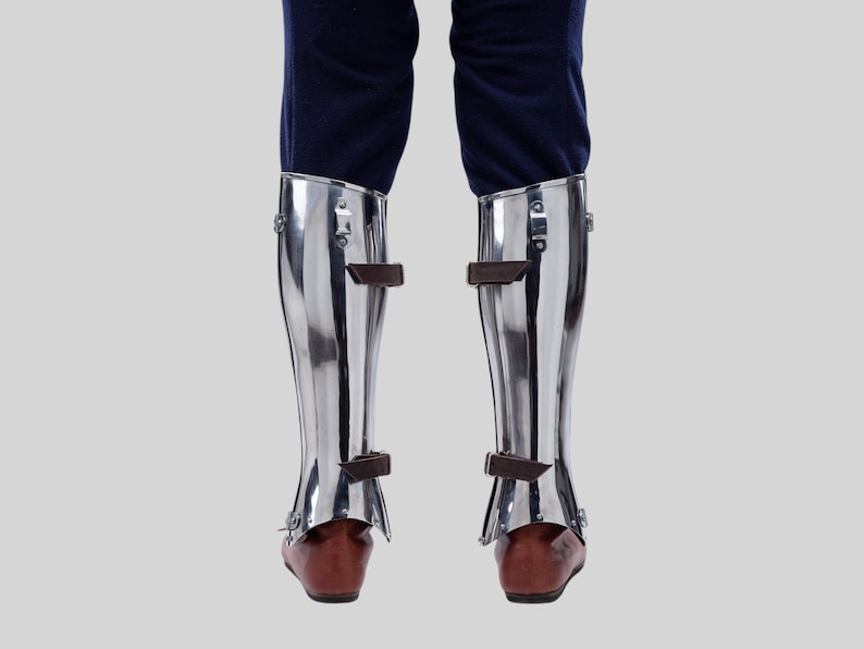 Medieval closed leg greaves with black leather straps for a secure fit