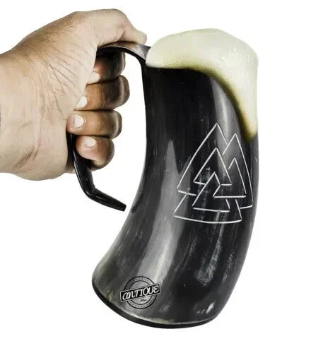 Medieval Viking drinking tankard made of natural ox horn, holding beer.