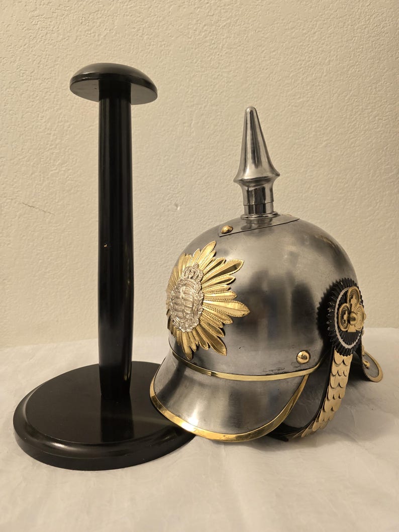 Side profile of a detailed Prussian medieval helmet replica showing Latin motto