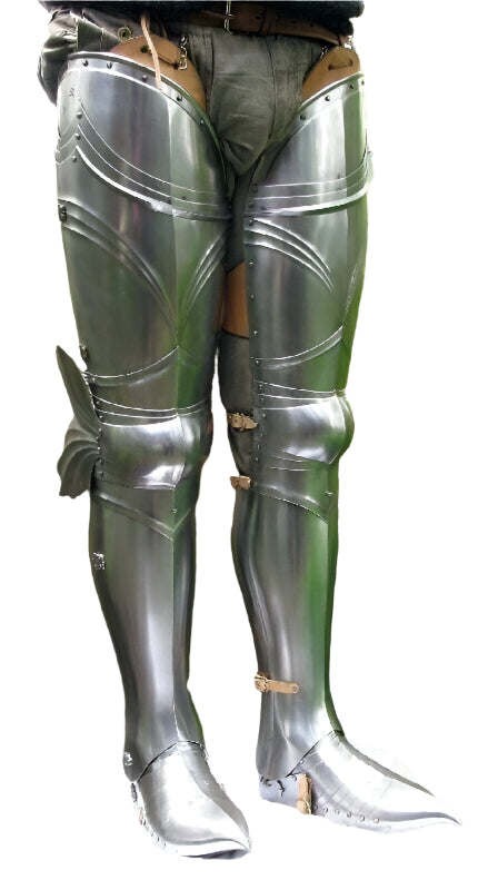 Pair of metallic armor leg guards in a forest setting
