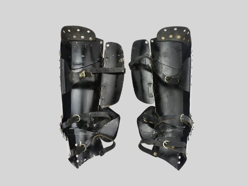 Wearable knight leg armor set displayed on a stand made of polished steel