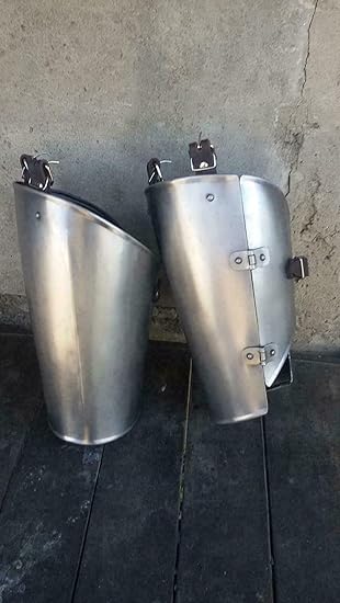 Two metallic knee pads on a concrete floor against a wall.