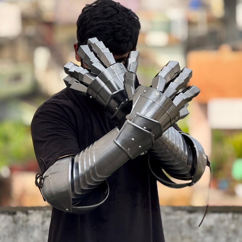 Close-up of articulated steel armor gloves with layered plate protection for LARP and cosplay