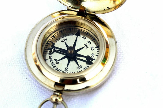 Close-up front view of Artisans Hub brass pocket compass showing detailed dial and needle