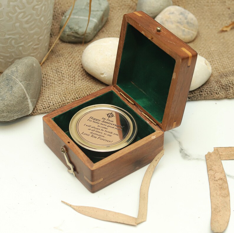 Custom engraved anniversary compass showing different font styles for personalization.