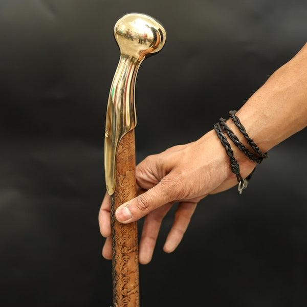 Hand-carved wooden walking cane with polished brass handle and nautical floral design