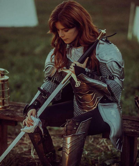 Person in medieval armor holding a sword outdoors