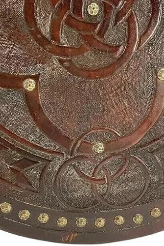 Back side of wooden Viking shield showing leather hand straps for wearing