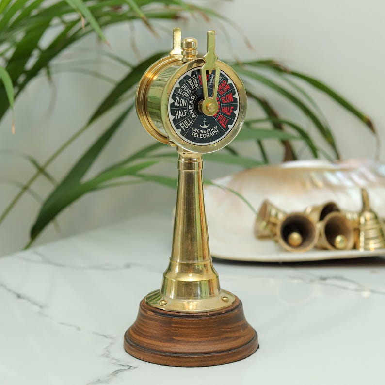 Nautical maritime décor – brass engine room telegraph displayed on wooden desk.