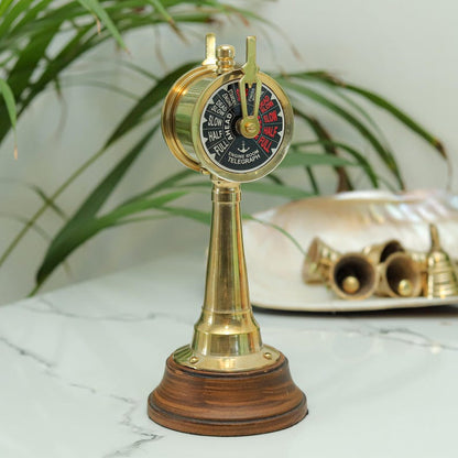 Nautical maritime décor – brass engine room telegraph displayed on wooden desk.