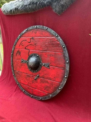 Red Norse wooden shield mounted on wall as medieval decor piece