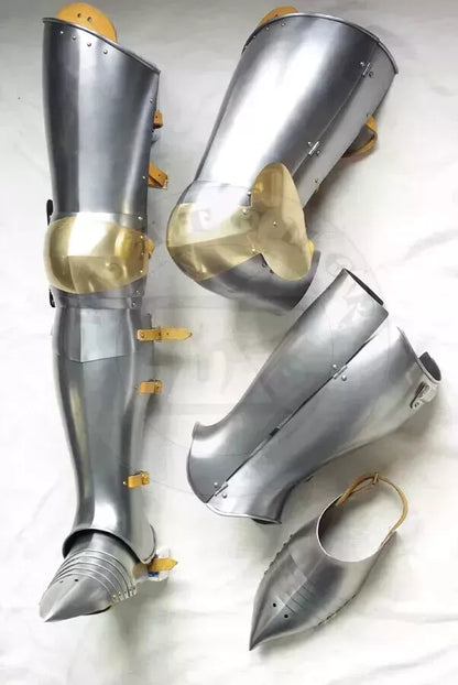 Pair of metallic armor leg guards on a white background