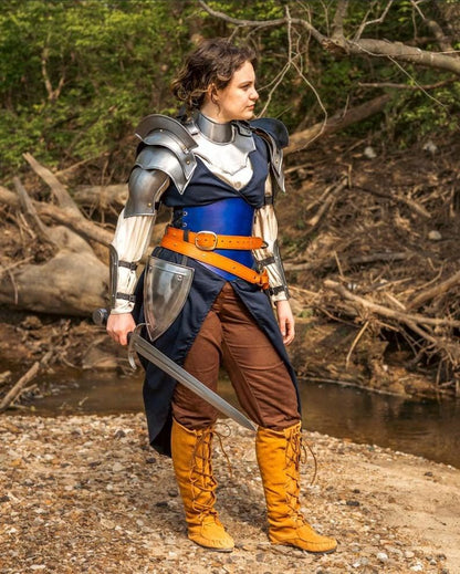 Close-up of polished steel pauldrons and gorget showing elegant curvature and riveted detailing for a heroic female warrior look.


