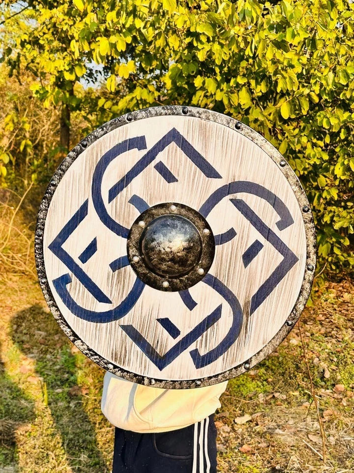 Norse round wooden shield mounted as wall decor in a medieval-themed room