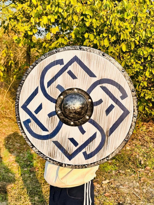Norse round wooden shield mounted as wall decor in a medieval-themed room