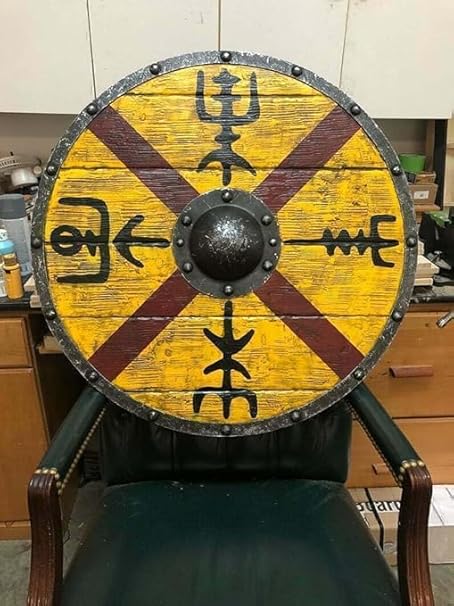 Viking shield mounted on a wall as a striking piece of medieval home decor.