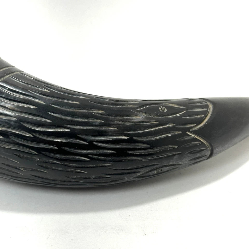 Close-up of vintage carved Viking drinking horn showing detailed etchings