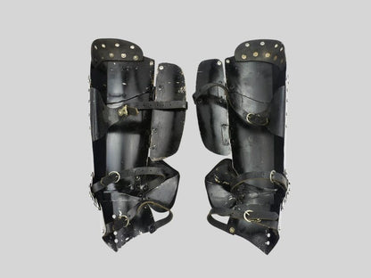 Wearable knight leg armor set displayed on a stand made of polished steel

